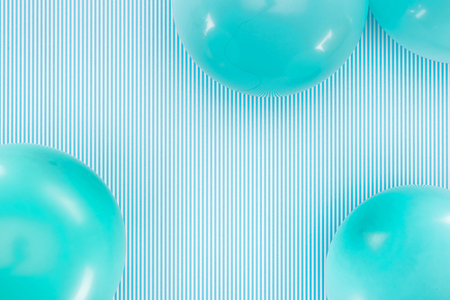 Top view of blue balloons on blue and white striped background