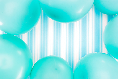 Top view of blue balloons frame on striped background