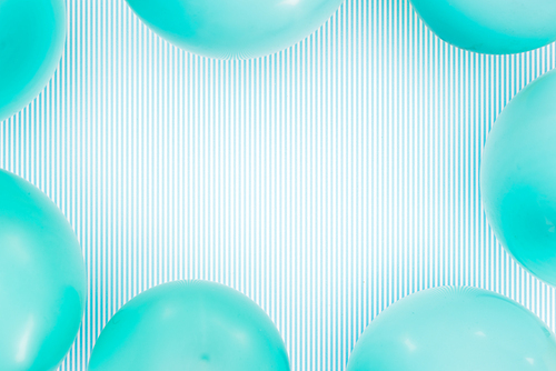 Top view of pastel blue balloons frame on striped blue background