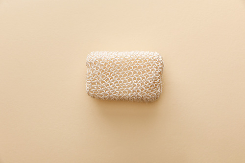 top view of natural bath sponge on beige background