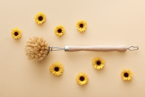 top view of body brush on beige background with flowers