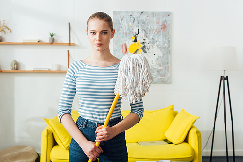 Beautiful woman holding mop and  in living room