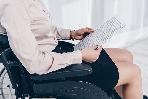 Cropped view of disabled recruiter with papers on wheelchair in office