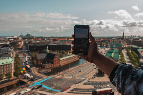 Cropped view of tourist taking picture on smartphone with Copenhagen city at background, Denmark