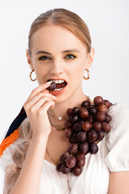 rustic blonde woman biting grapes isolated on white