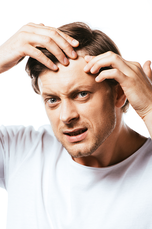 Displeased man  while touching hair isolated on white