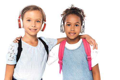 multicultural schoolkids listening music in wireless headphones while  isolated on white