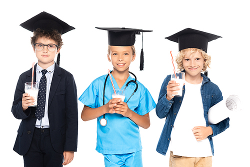 children in graduation caps dressed in costumes of different professions holding glasses with fresh milk isolated on white
