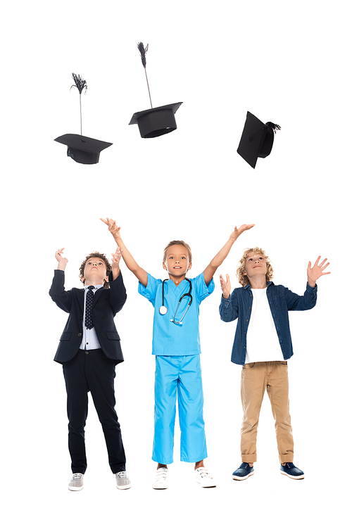 children dressed in costumes of different professions throwing in air graduation caps isolated on white