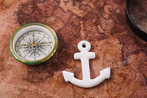 white anchor near compass on old world map