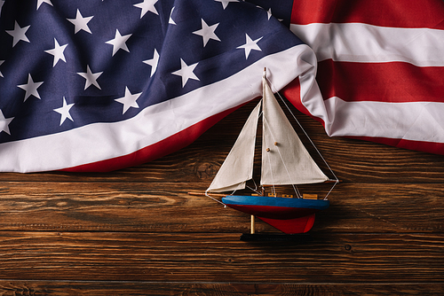 top view of leather crafted ship on wooden surface with American national flag