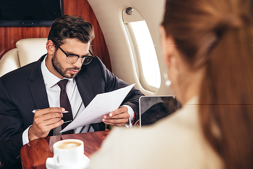 selective focus of businessman holding paper in private plane