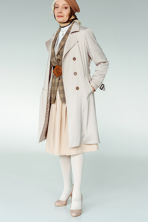 Full length of elegant elderly woman in coat  on white background