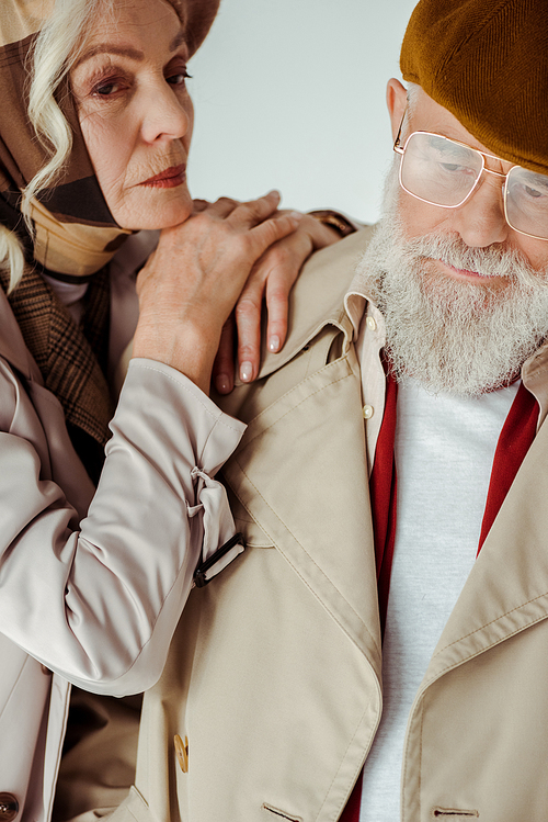 Elegant woman embracing stylish senior man isolated on grey