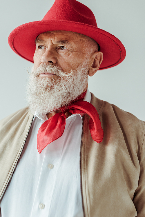 Stylish senior man in red hat looking away isolated on grey