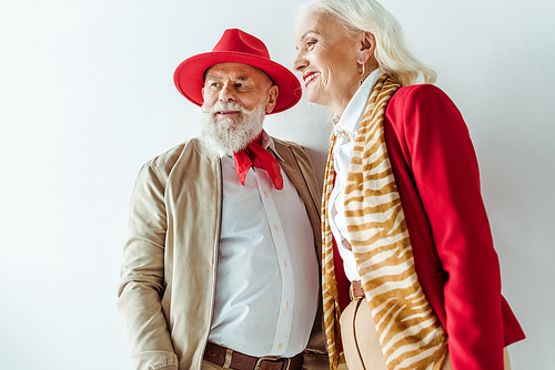Stylish senior couple smiling away on white background