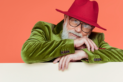 Stylish senior man in jacket and eyeglasses  on white background isolated on coral