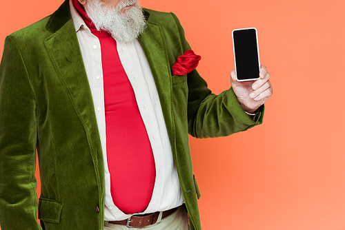 Cropped view of stylish senior man holding smartphone with blank screen isolated on coral