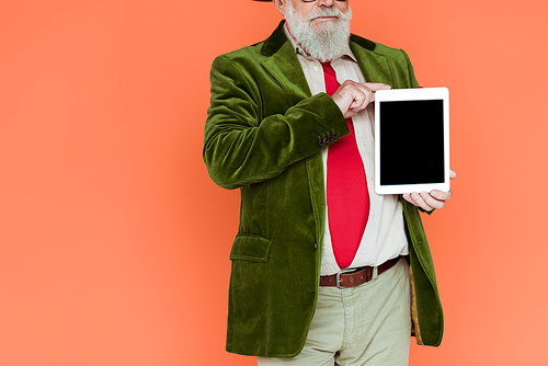 Cropped view of stylish senior man holding digital tablet with blank screen isolated on coral