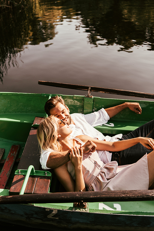 happy young couple looking at each other while sitting in boat