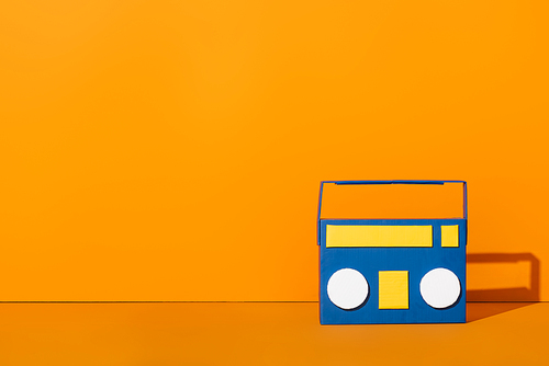 blue paper cut boombox on orange with copy space