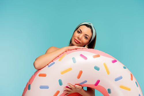 Woman with inflatable ring smiling and  isolated on blue