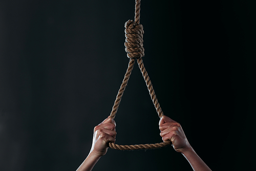 cropped view of despaired woman going to commit suicide while holding hanging rope noose isolated on black