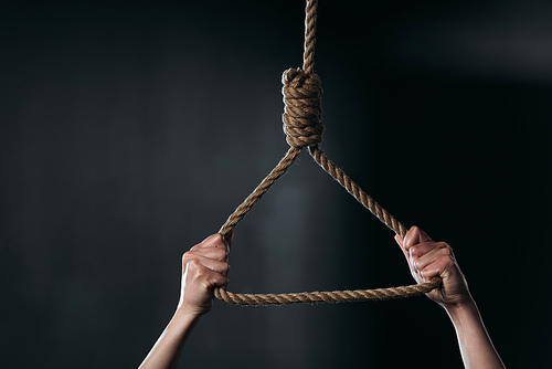cropped view of woman holding hanging rope loop on black background