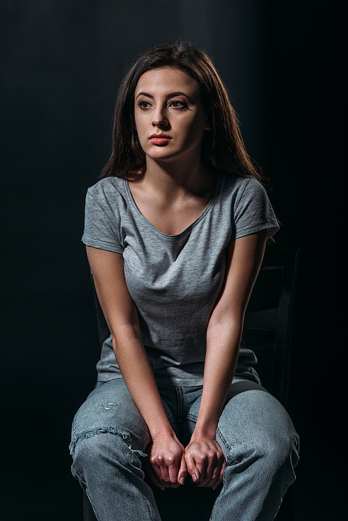depressed girl looking away while thinking about suicide isolated on black