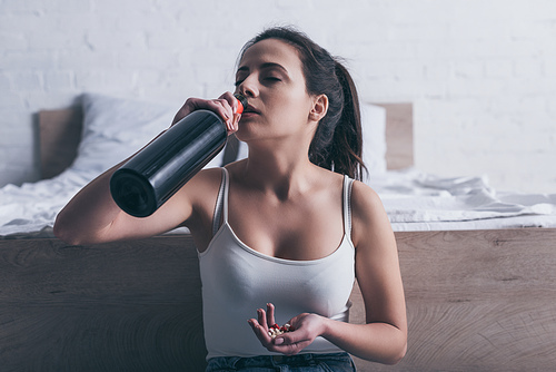 depressed young woman drinking alcohol and going to commit suicide by overdosing medicines