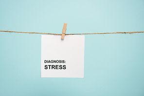 Card with diagnosis stress lettering on rope with pin isolated on blue