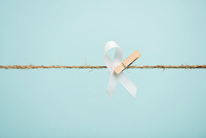 White ribbon with pin on rope isolated on blue