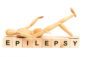 Wooden doll on cubes with epilepsy lettering on white background