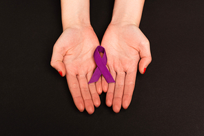 Top view of purple ribbon on hands of woman isolated on black