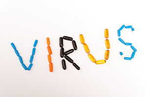 Top view of virus lettering from pills on white background