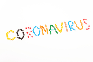 Top view of coronavirus lettering from colorful pills isolated on white