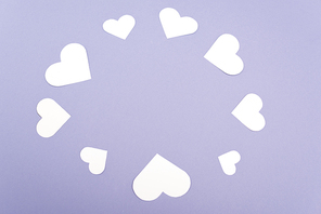 Frame from white paper hearts isolated on purple