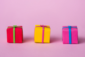 colorful and small paper gift boxes on pink