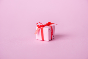 small paper present with ribbon and bow on pink