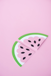 sliced paper watermelon with black seeds isolated on pink