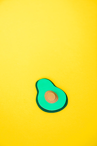 green and decorative paper avocado isolated on yellow