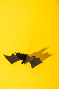 black origami bat on yellow with copy space