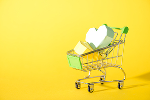 origami hearts in toy shopping cart on yellow