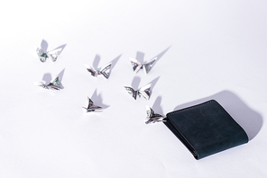 decorative money origami butterflies near wallet on white