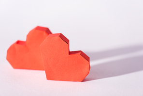 selective focus of red origami hearts on white with copy space