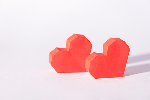 red origami hearts on white with copy space