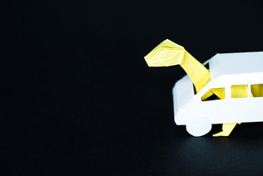 paper dinosaur in carton car on black