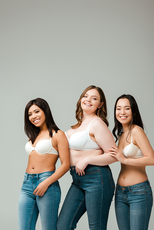 Multicultural women smiling and  isolated on grey