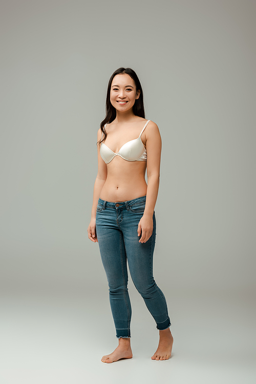 happy overweight asian girl standing on grey