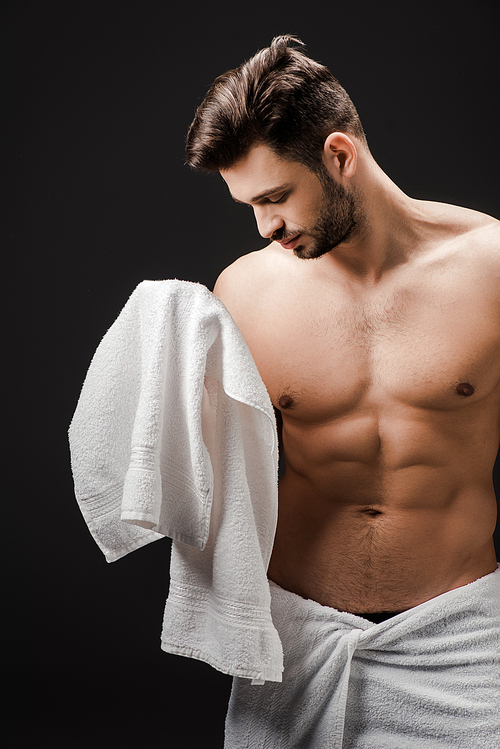 bearded brunette man with towel isolated on black